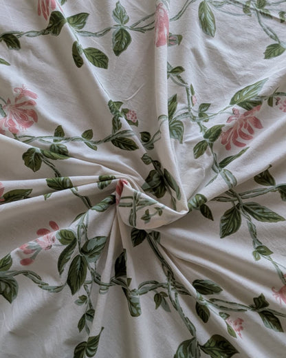 Close-up of Everyday Cotton fabric with pink flowers and green leaves on ivory