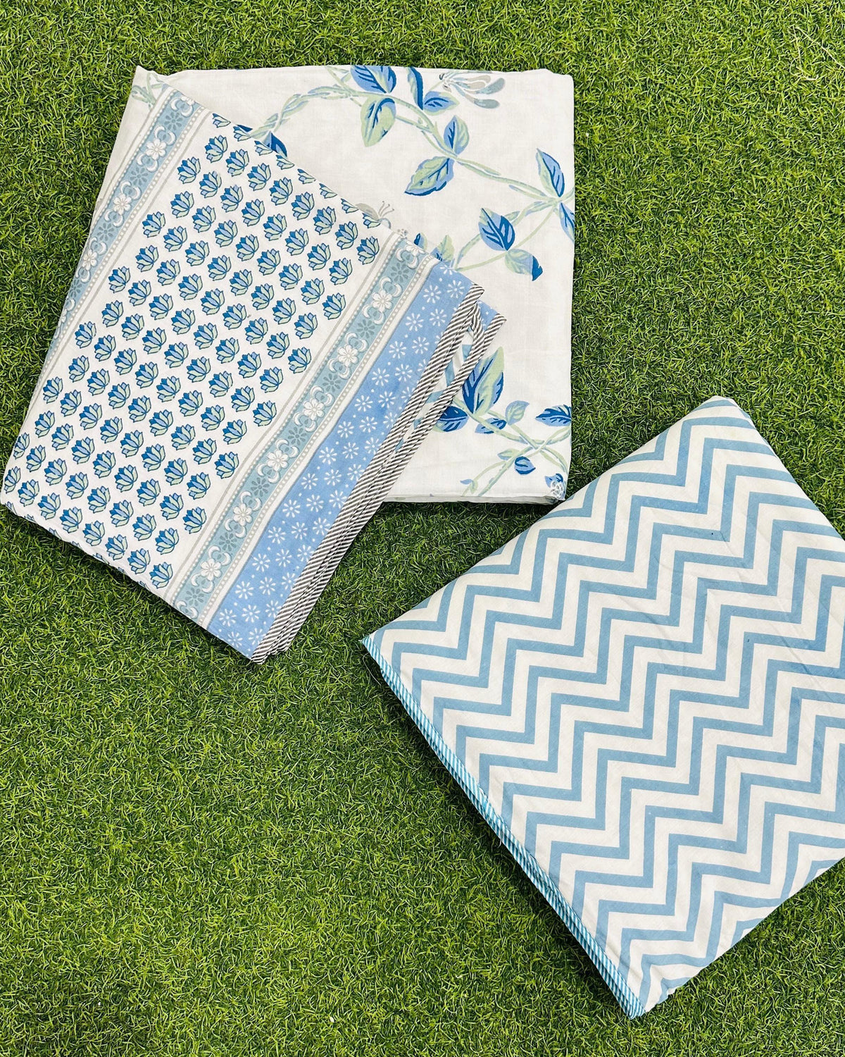 Reversible blue floral mulmul dohar folded to show the printed side and the chevron reverse