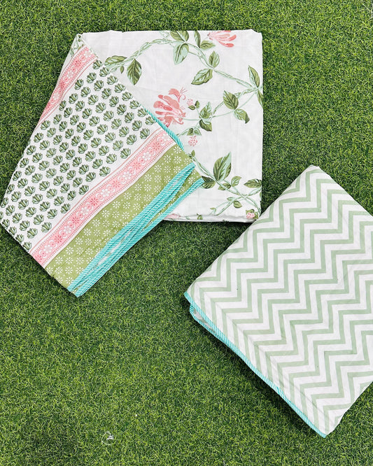 Reversible pink and green floral mulmul dohar folded to show the printed side and the chevron reverse