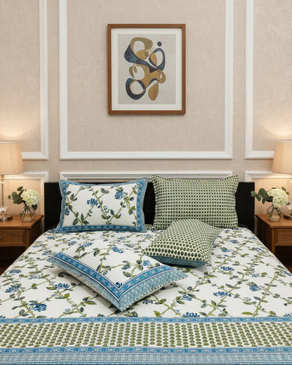Blue floral cotton bedsheet with green vine trails and two matching pillow covers in a panelled bedroom