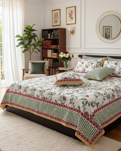 Red floral cotton bedsheet with a green dotted border and matching pillow covers in a classic bedroom