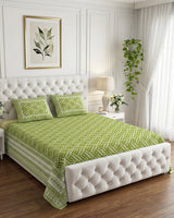 Leher Green bedsheet, leaf-green interlocking key-pattern print, on a tufted ivory bed
