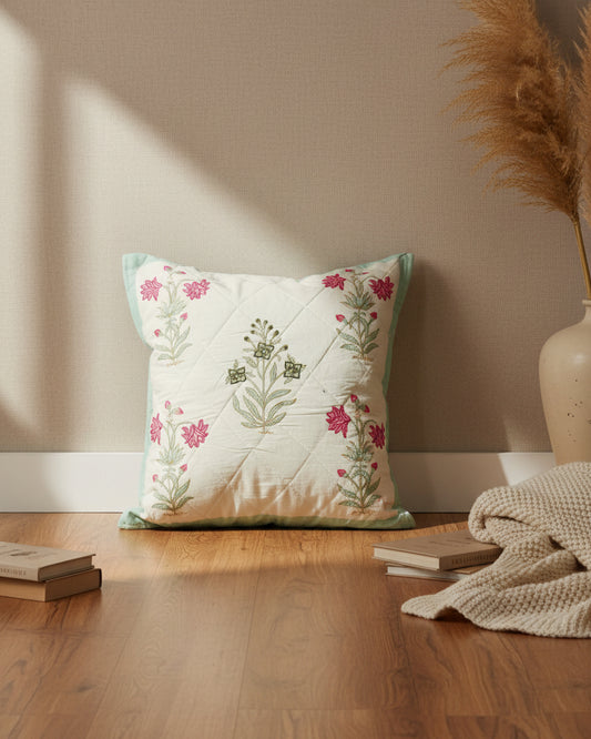 Malika blue quilted cushion cover styled with pink, mint, and green floral motifs