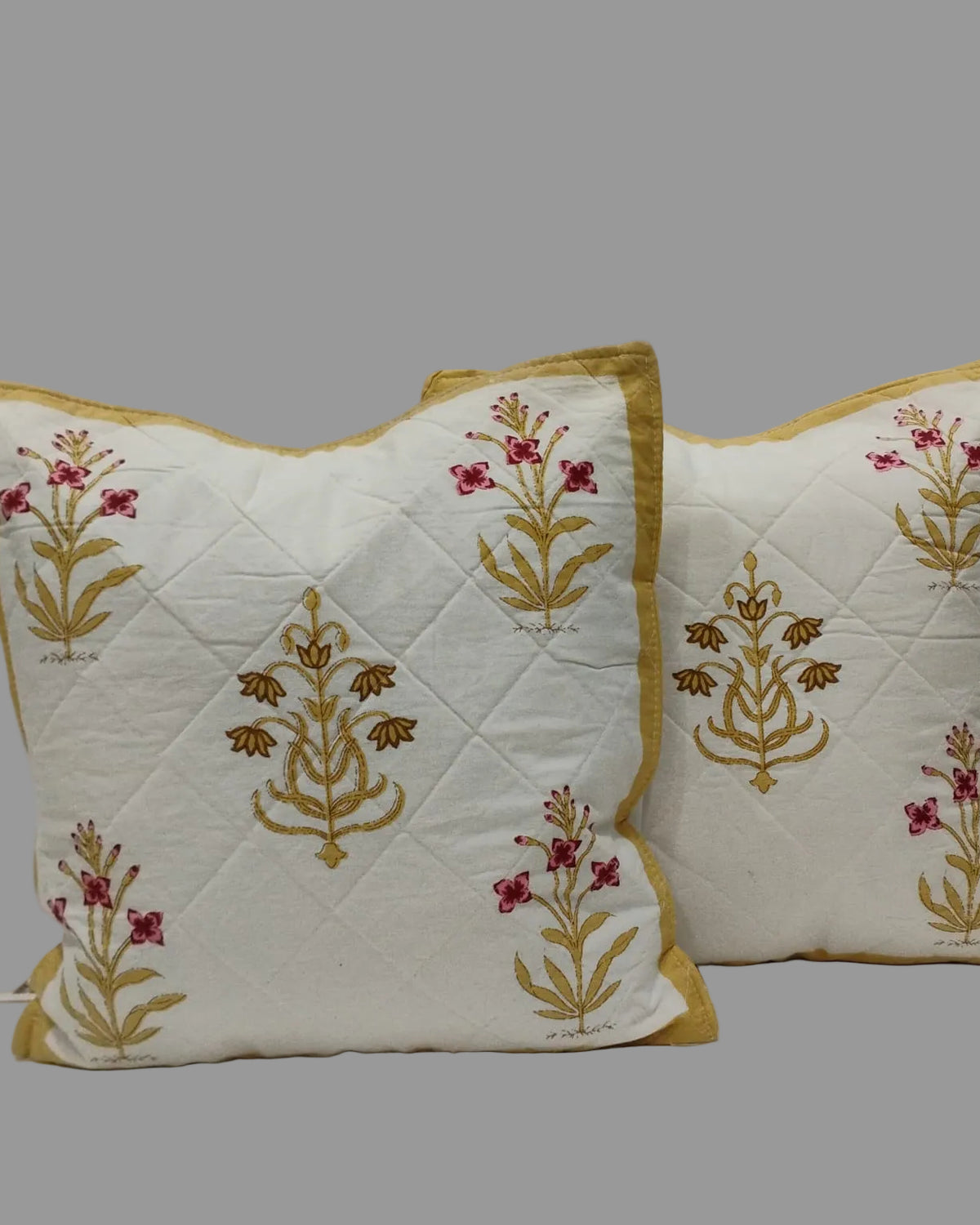 Pair of Mehek yellow quilted cushion covers with pink and ochre floral motifs