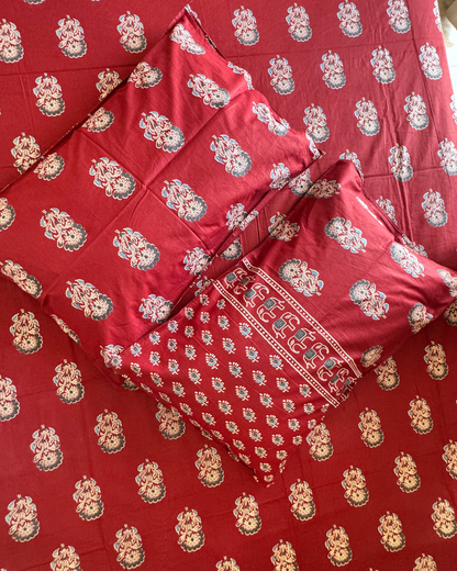 Close-up of Mehfil Red pillow covers and bedsheet showing ivory floral buta on red