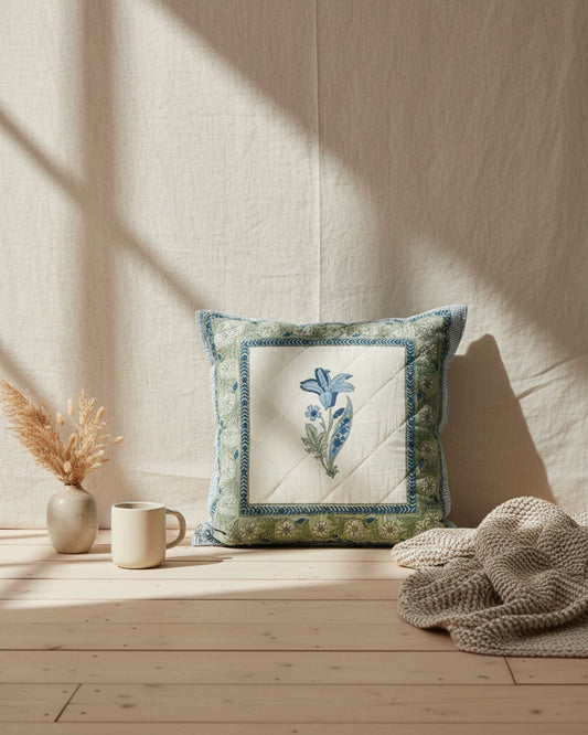 Mridula blue quilted cushion cover styled with a blue flower panel and green floral border