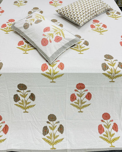 Close-up of ivory cotton fabric with terracotta and grey botanical carnation motifs and a booti pillow cover