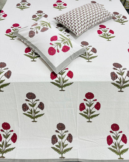 Close-up of ivory cotton fabric with red and grey botanical carnation motifs and a booti pillow cover