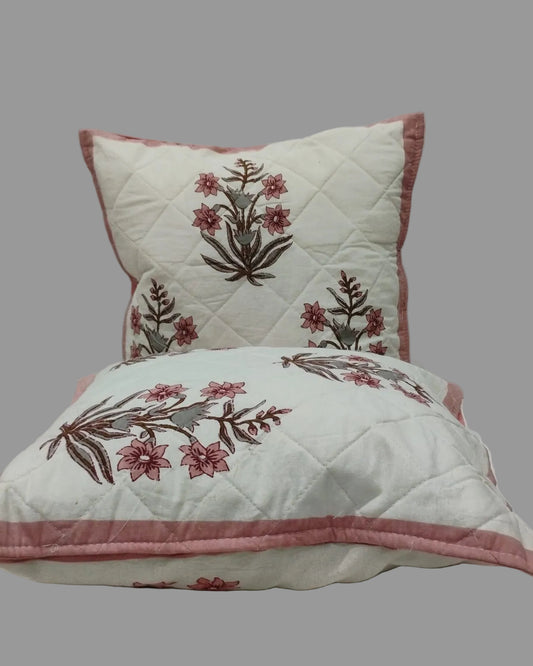 Two Neerja pink quilted cushion covers stacked to show the floral print and pink trim