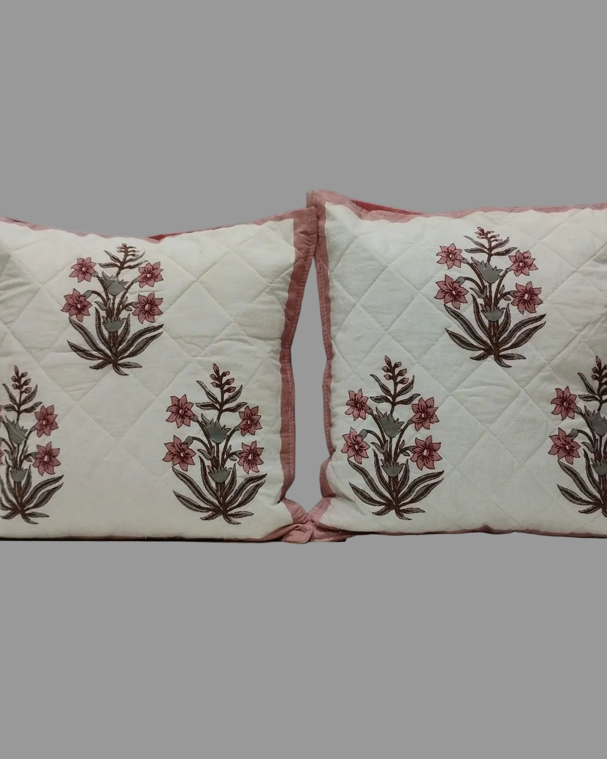 Pair of Neerja pink quilted cushion covers with repeating pink floral motifs