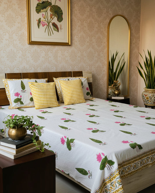 Bed with floral patterned bedspread and pillows in a room.