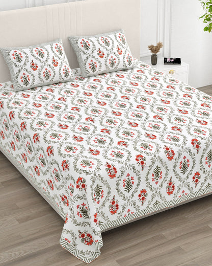 Parijat Orange bedsheet, white floral ogee jaal with coral-orange flowers, in a studio shot against a cream headboard