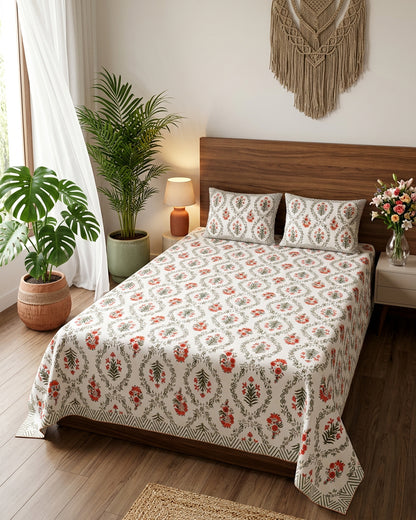 Parijat Orange bedsheet, white floral ogee jaal with coral-orange flowers, on a bed with a wooden headboard with macramé and plants
