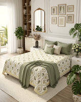 Parijat Yellow bedsheet, white floral ogee jaal with dark olive flowers, in a bedroom with a sage throw and cushions