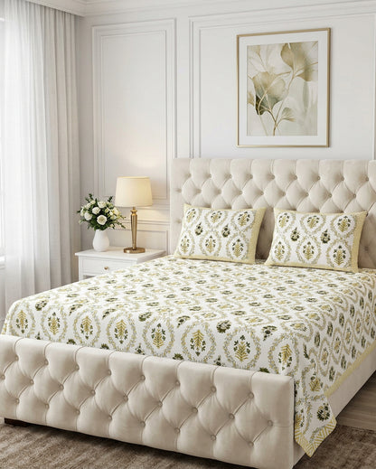 Parijat Yellow bedsheet, white floral ogee jaal with dark olive flowers, on a tufted ivory bed