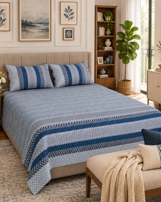 Preet Light Blue Everyday Cotton bedsheet with a dotted grey-blue ground and deep blue stripe bands, with a cream throw