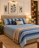 Preet Light Blue bedsheet styled with navy and beige cushions and a knit throw