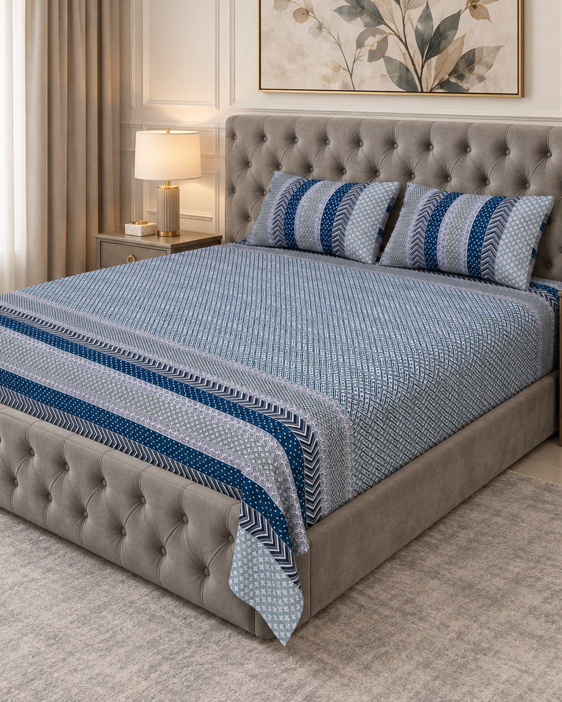 Preet Light Blue bedsheet with deep blue stripe bands on a grey tufted bed