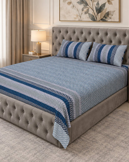 Preet Light Blue bedsheet with deep blue stripe bands on a grey tufted bed
