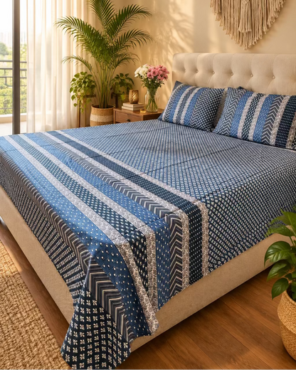 Preet Blue bedsheet with blue and ivory stripe bands on a bed with a light headboard