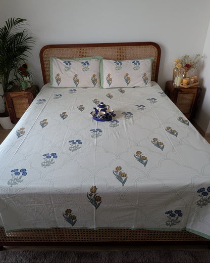 Blue and ochre floral booti cotton bedsheet with a green scalloped pattern and border