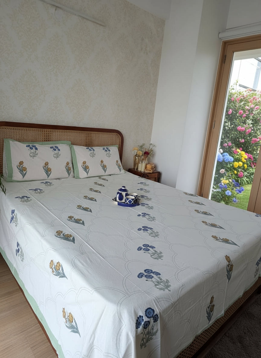 Bedroom with a bed featuring a floral patterned bedspread and pillows.