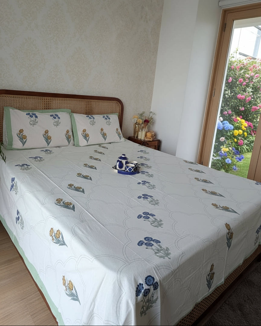 Bedroom with a bed featuring a floral patterned bedspread and pillows.