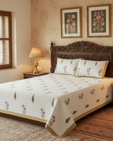 Pink orchid floral cotton bedsheet with gold cypress motifs styled on a carved wooden bed