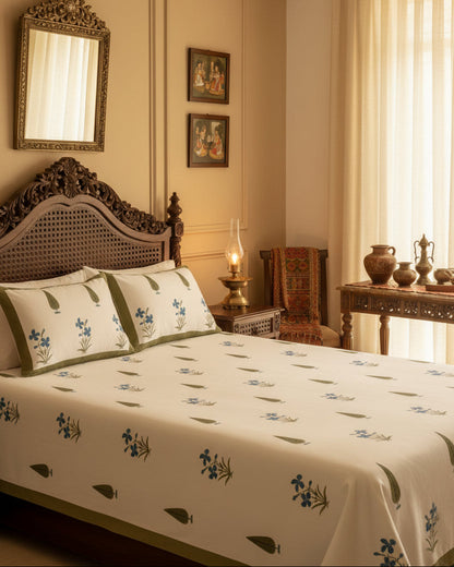 Blue orchid floral cotton bedsheet with olive cypress motifs styled on a carved wooden bed