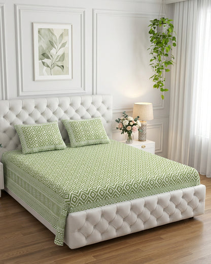 Ratna Green bedsheet, all-over sage-green nested-diamond print, on a tufted ivory bed