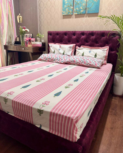 Rekha pink striped cotton bedsheet styled with reversible floral pillow covers in a bedroom