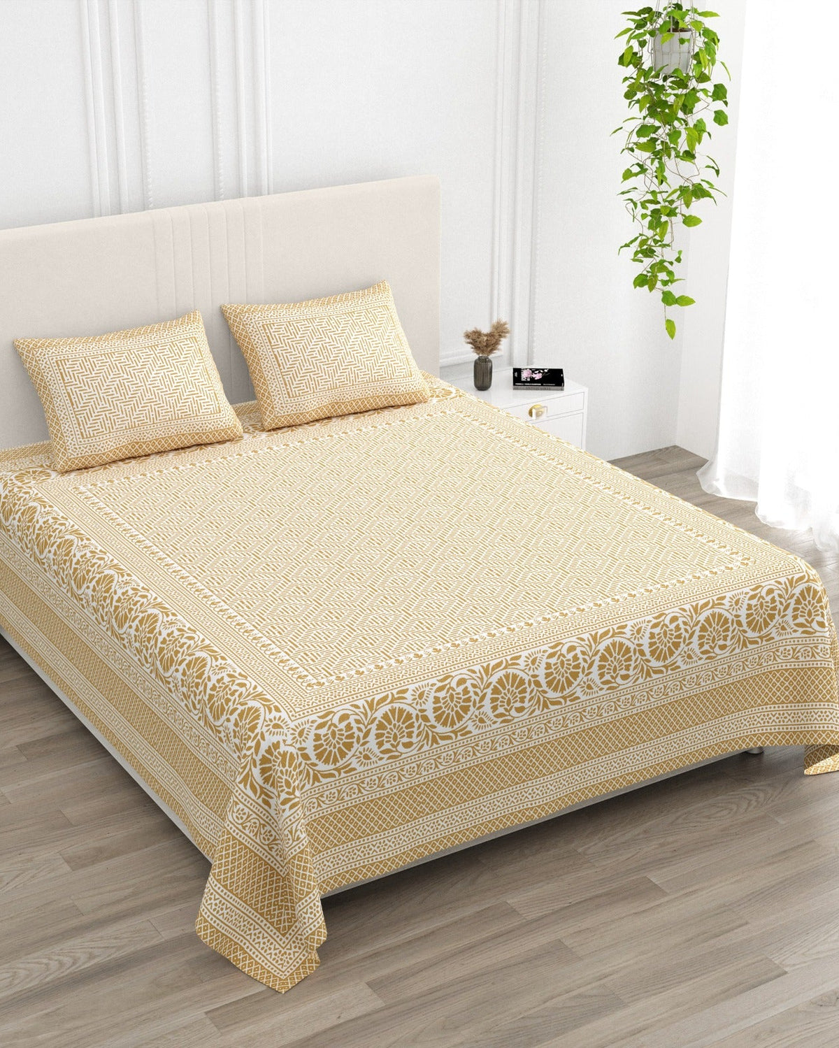 Sagar Beige bedsheet, mustard-gold geometric maze with a medallion-flower border, in a studio shot against a cream headboard