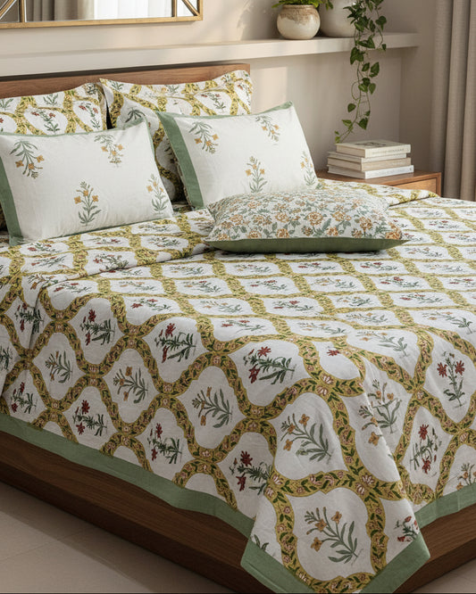 Bed with floral patterned bedsheet and 2 reversible pillow in green yellow and red