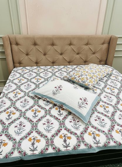 Mustard and pink floral cotton bedsheet in a grey trellis with a blue border