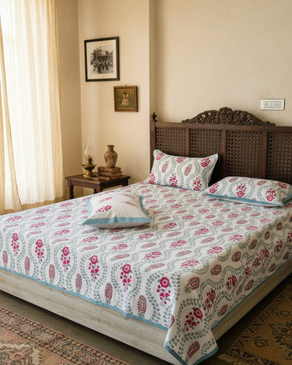 Close-up of sage trellis cotton fabric with magenta florals and a powder blue border pillow cover