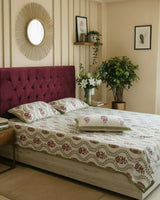 Olive trellis floral cotton bedsheet with maroon flowers styled on a maroon tufted bed