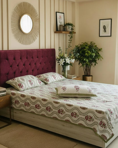 Olive trellis floral cotton bedsheet with maroon flowers styled on a maroon tufted bed