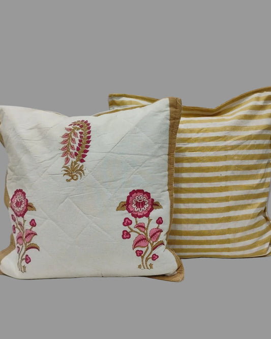 Surmayi cushion cover shown beside a mustard striped reverse with pink floral motifs