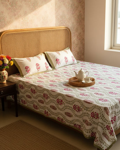 Olive trellis floral cotton bedsheet with maroon flowers styled on a cane headboard bed