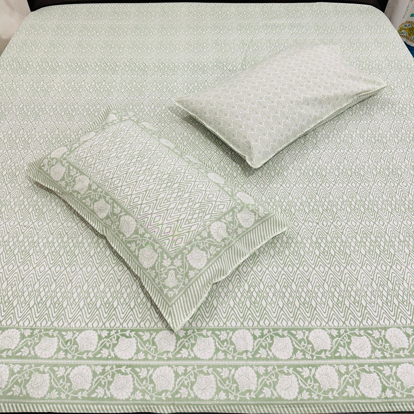 Green and white patterned bedding set on a bed