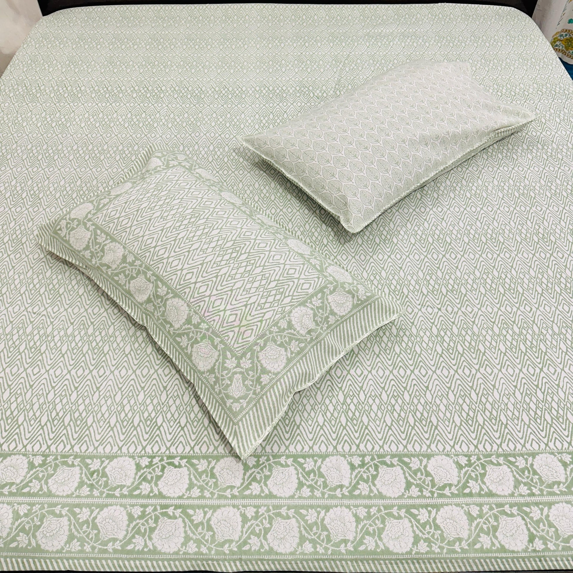 Green and white patterned bedding set on a bed