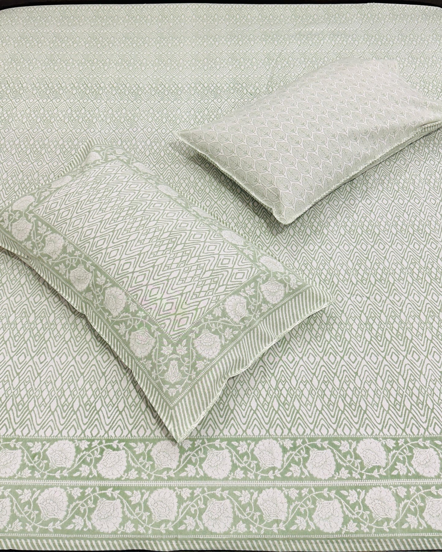 Green and white patterned bedding set on a bed