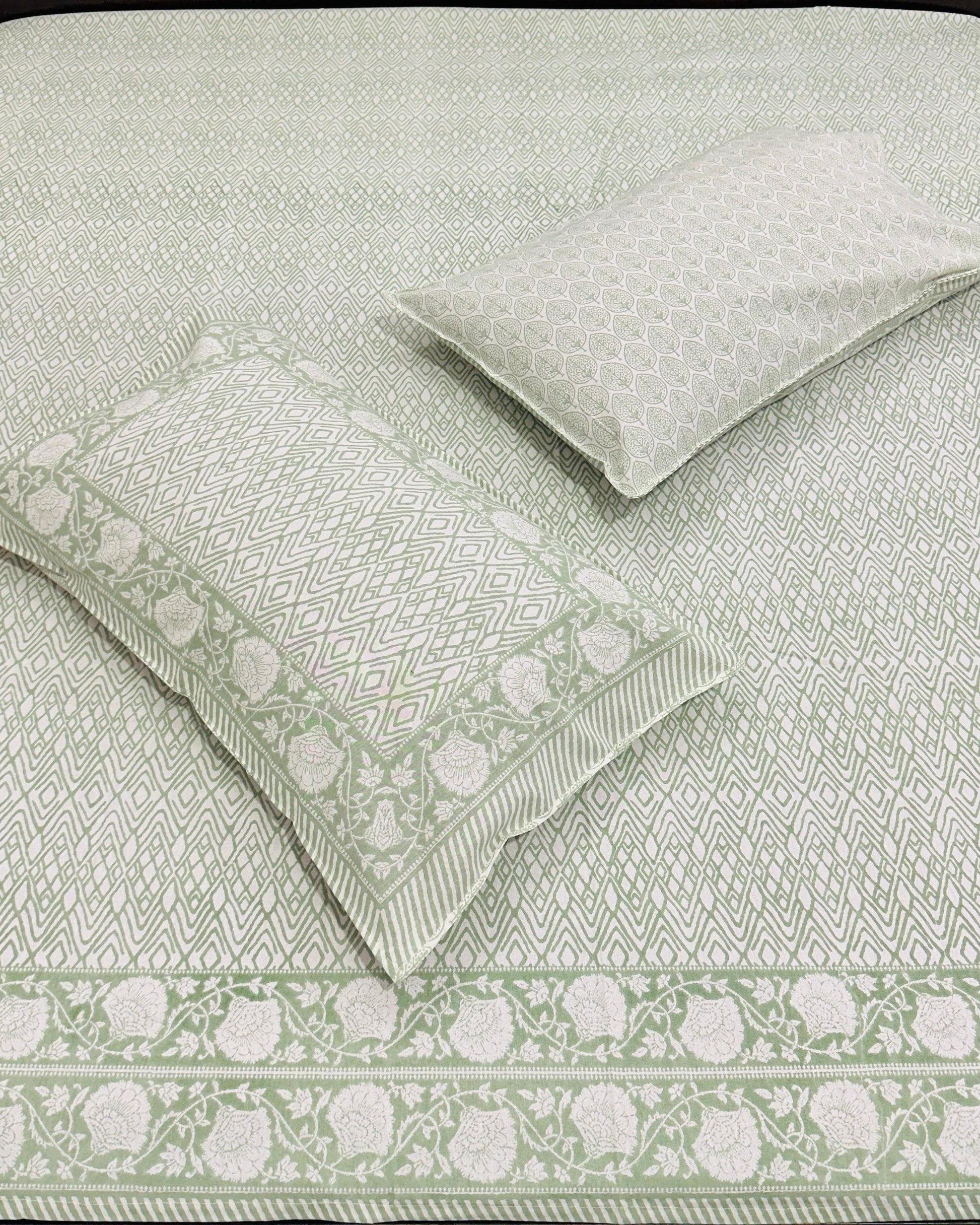 Green and white patterned bedding set on a bed