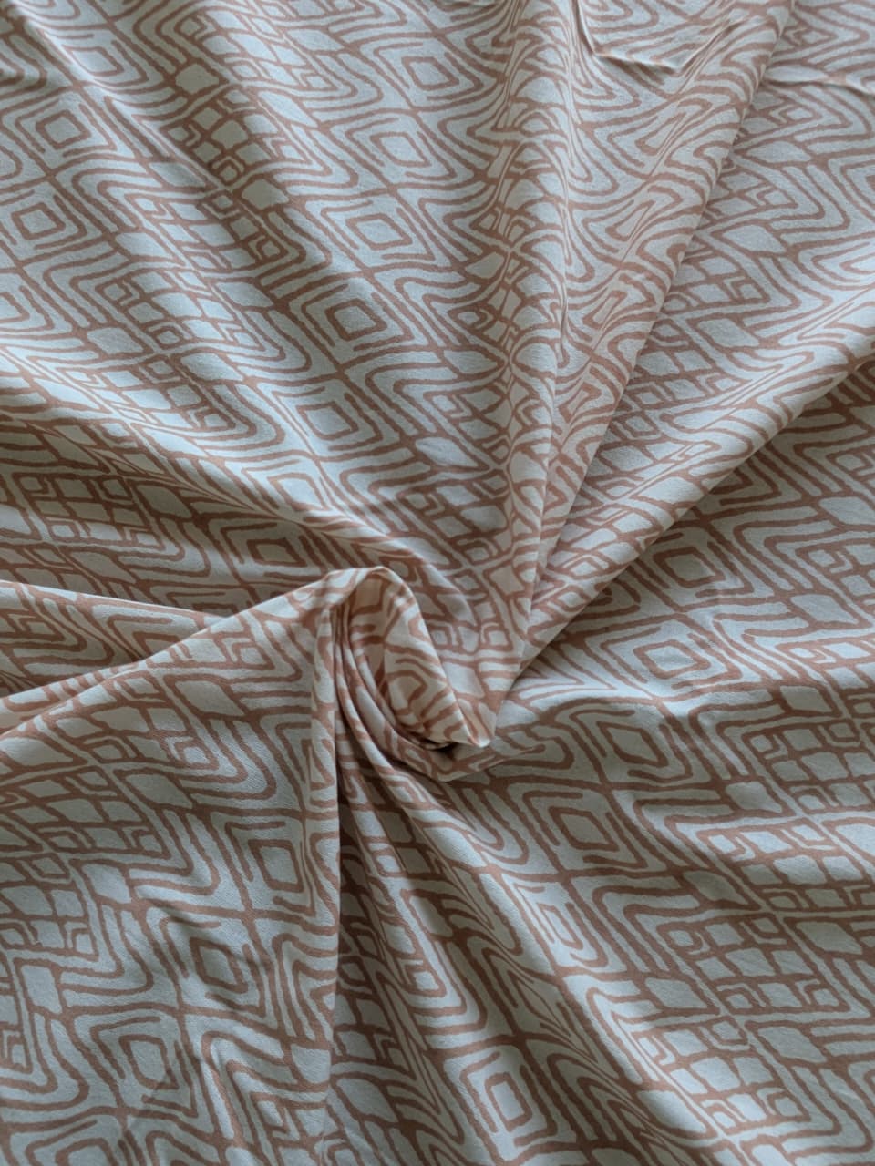 Cotton bedsheet fabric with geometric pattern in pink and beige