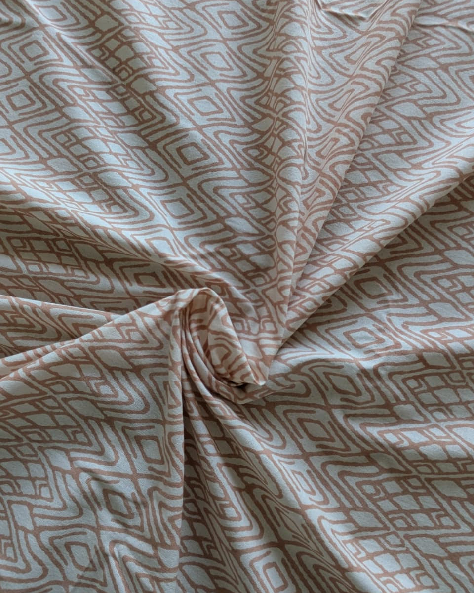 Cotton bedsheet fabric with geometric pattern in pink and beige