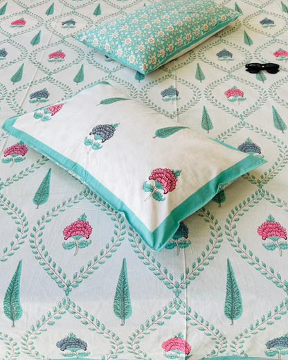 Close-up of teal green trellis cotton fabric with pink floral motifs and a floral reversible pillow cover