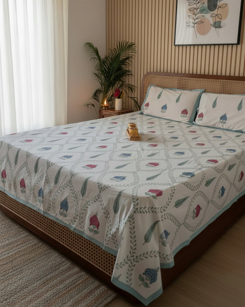 Bedroom with a bed covered in a patterned duvet, nightstand, and wall art.