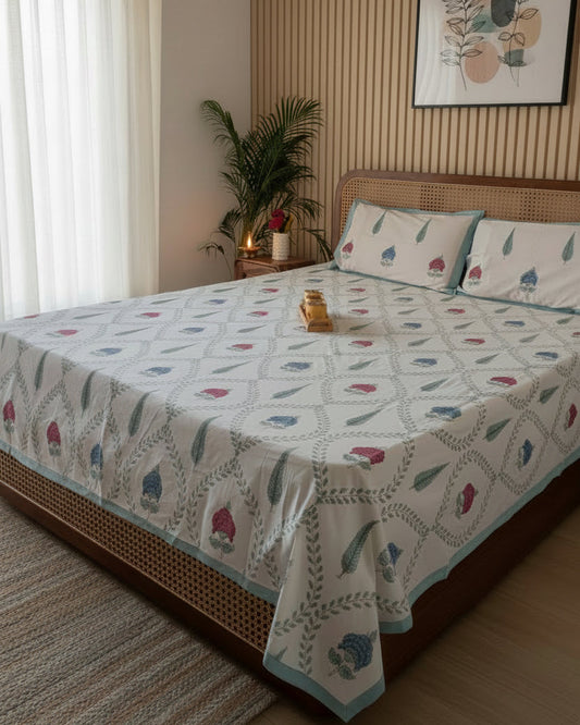 Bedroom with a bed covered in a patterned duvet, nightstand, and wall art.