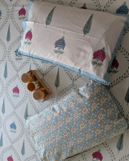 Reversible pillow covers with pink and blue floral jaal print and a blue ditsy floral reverse