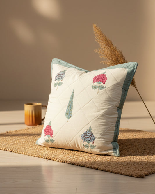 Tarangini blue quilted cushion cover styled with pink and blue flowers and a teal tree motif
